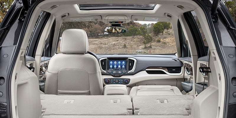 View through the trunk of a 2024 GMC Terrain with a cream interior and the back row of seats folded down