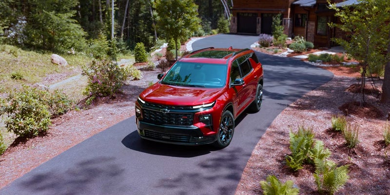 a RED 2024 Chevrolet Traverse parked in a driveway on a sunny day