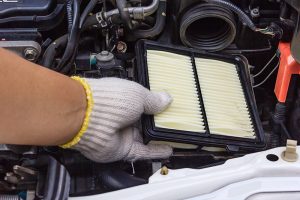 A Tech changing an air filter in a GMC vehicle. 